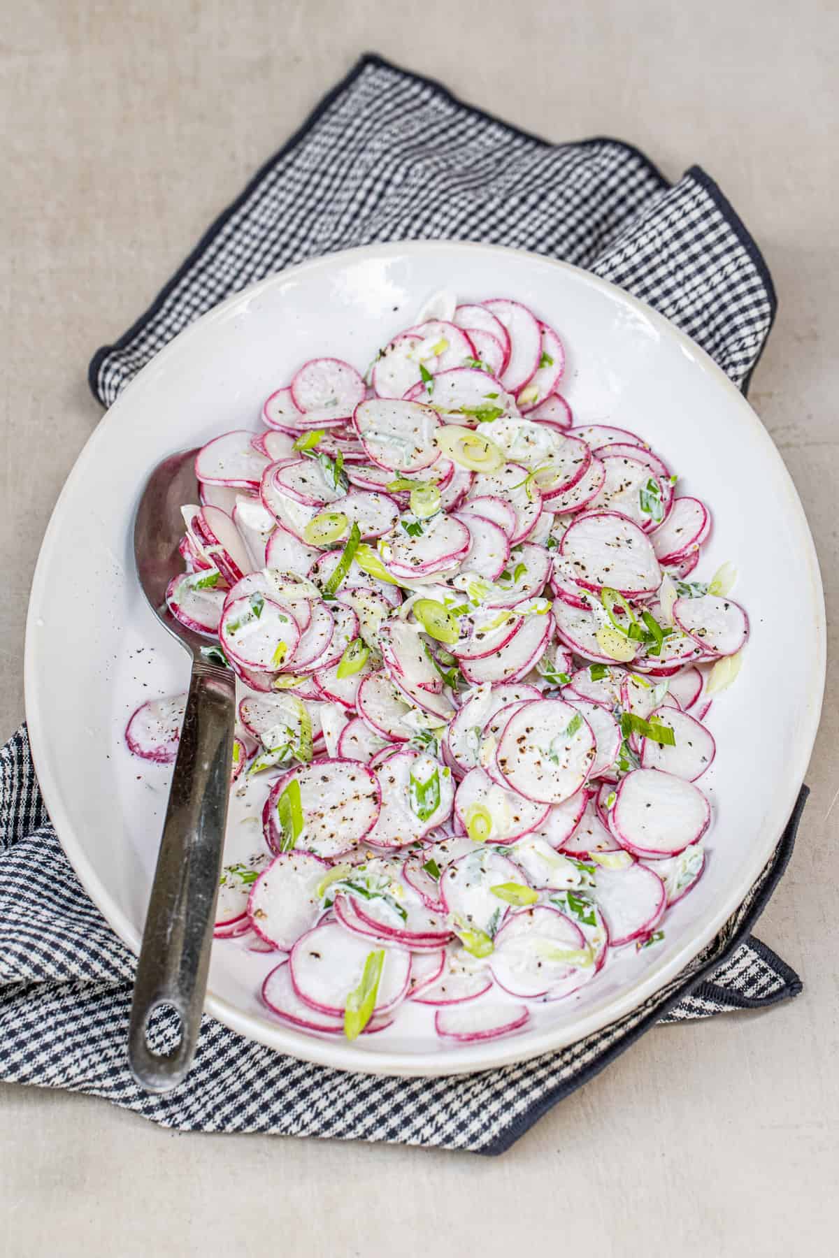 This easy radish salad is fresh, crunchy, and full of flavor. A plate of a radish salad tossed in creamy dressing.