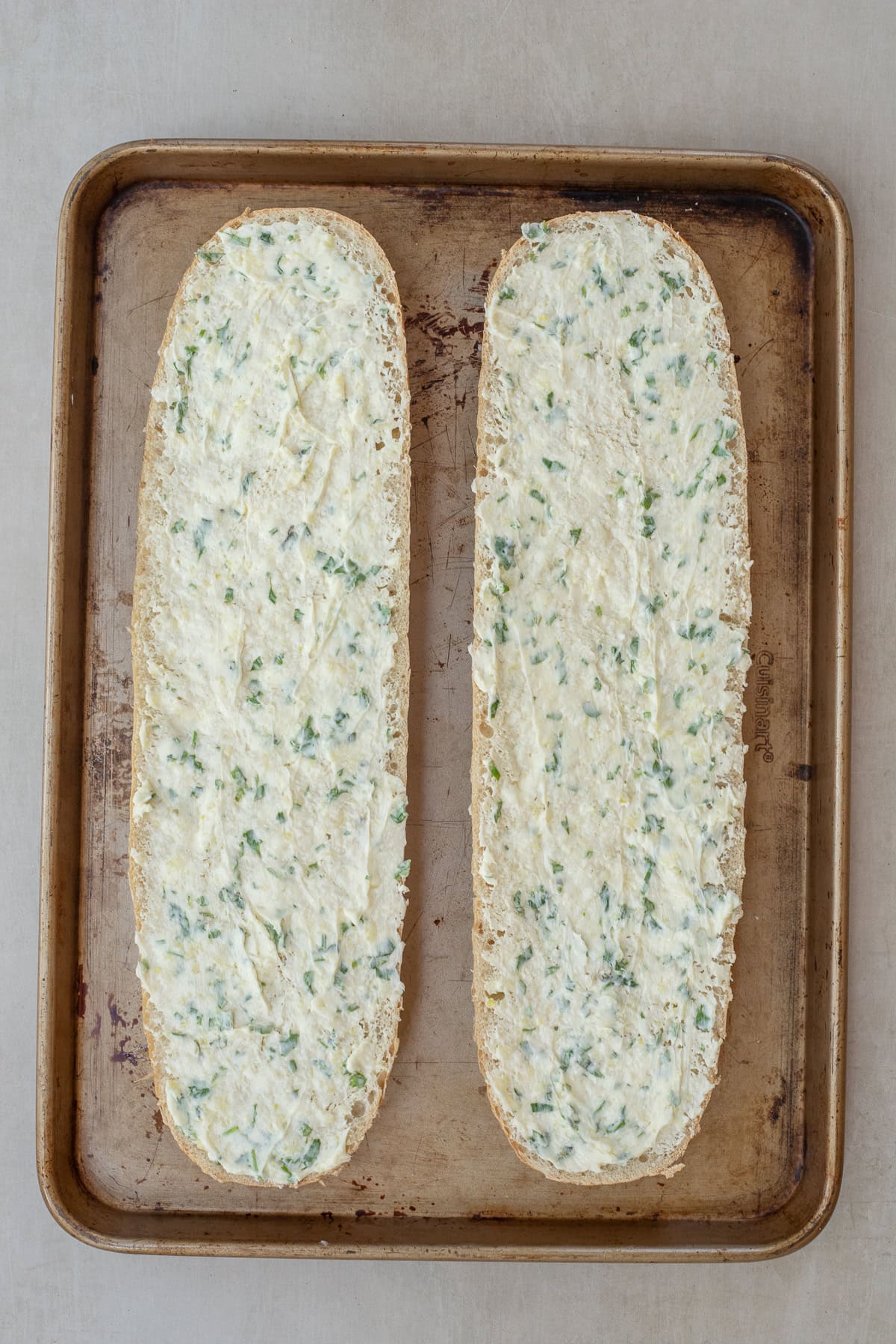 This easy garlic bread is made with fresh garlic, butter, parsley, and French bread. Sliced french bread with a layer of garlic butter.