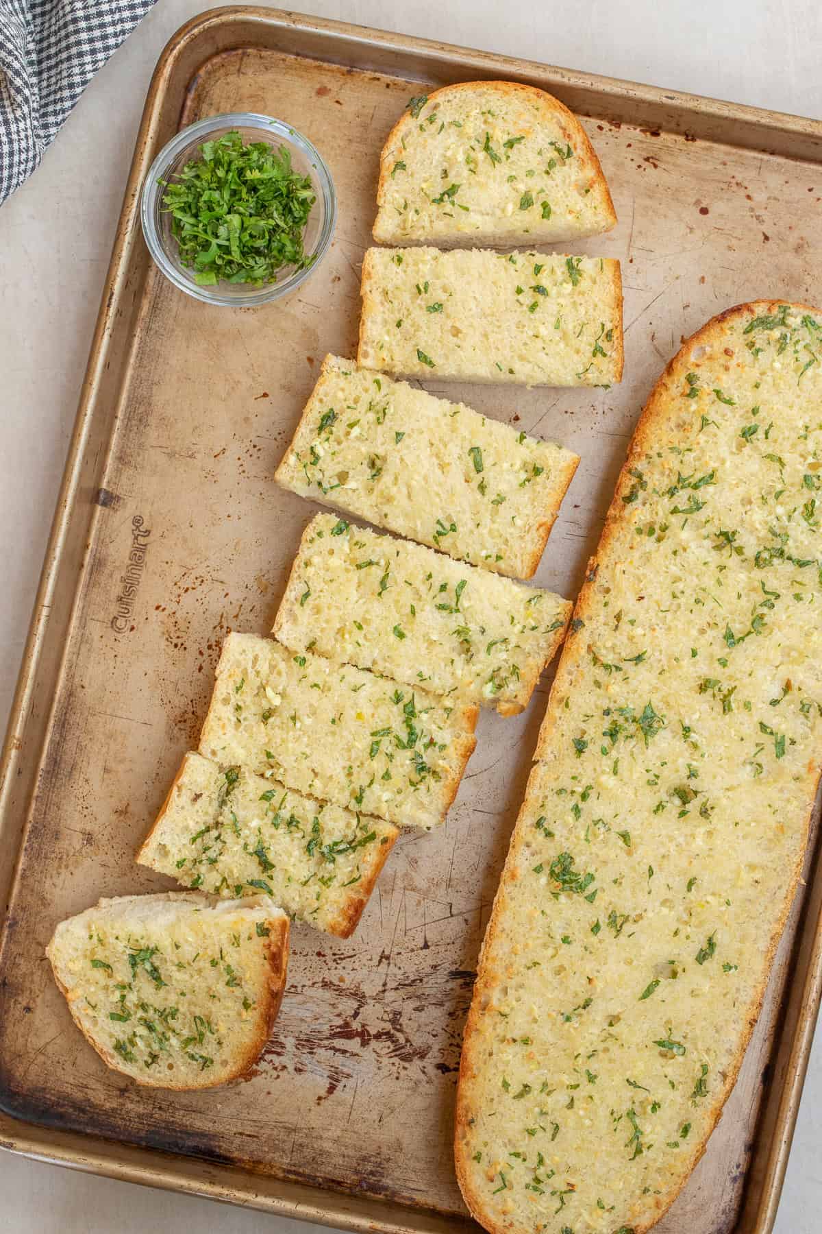 This simple garlic bread recipe makes a flavorful side dish in just 15 minutes. The garlic bread loaves with one side cut into slices.