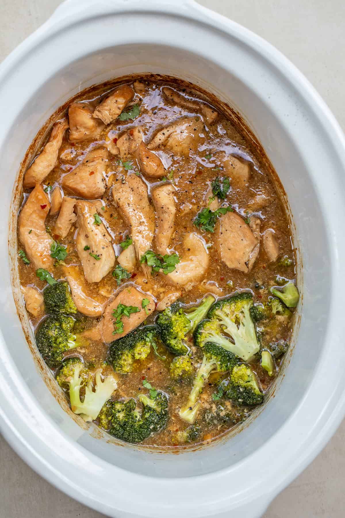 Tender chicken and broccoli cooked in a sweet and savory teriyaki sauce for an easy crockpot dinner. A slow cooker with the cooked chicken and broccoli.