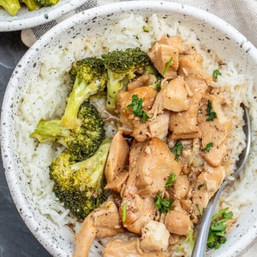 A bowl with the chicken teriyaki bowl, served with a side of broccoli.