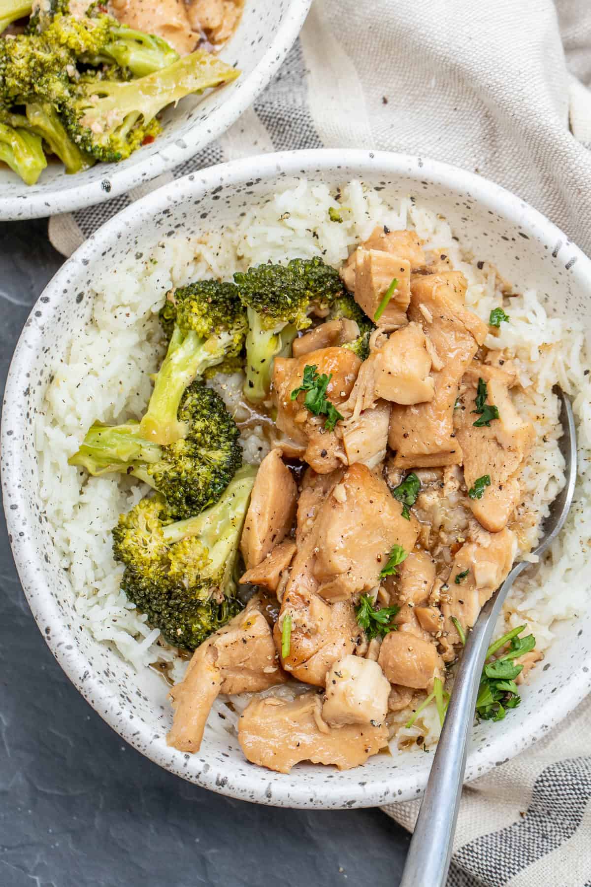 Easy crockpot teriyaki chicken served with tender broccoli and a flavorful homemade teriyaki sauce. A bowl with the chicken teriyaki bowl, served with a side of broccoli.