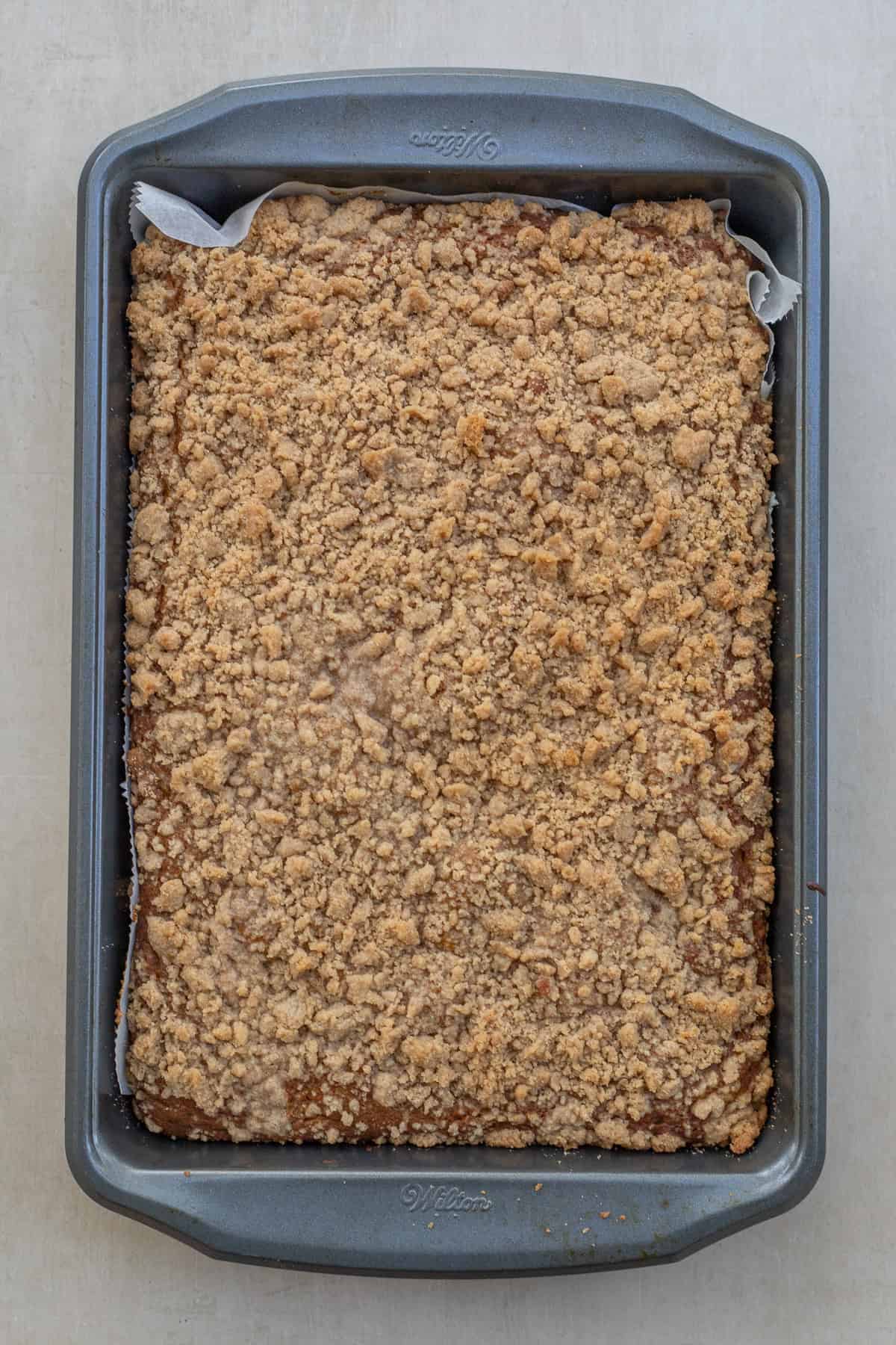 Easy pumpkin coffee cake made with real pumpkin and warm pumpkin pie spice, perfect for breakfast or brunch. A baking tin with the baked pumpkin coffee cake.
