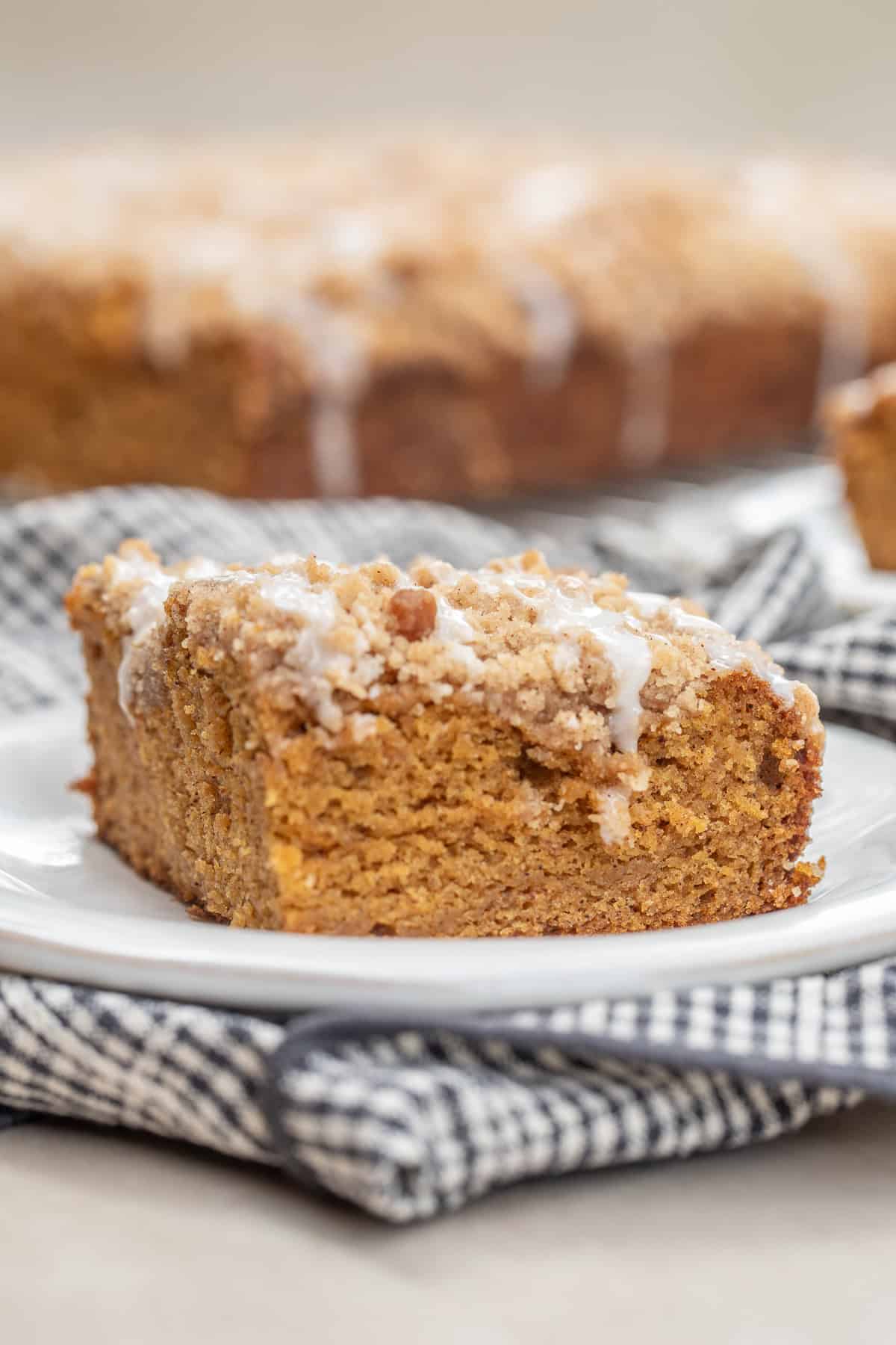 Homemade pumpkin coffee cake made with real pumpkin puree, warm spices, and a buttery crumb topping. A slice of pumpkin coffee cake on a plate.