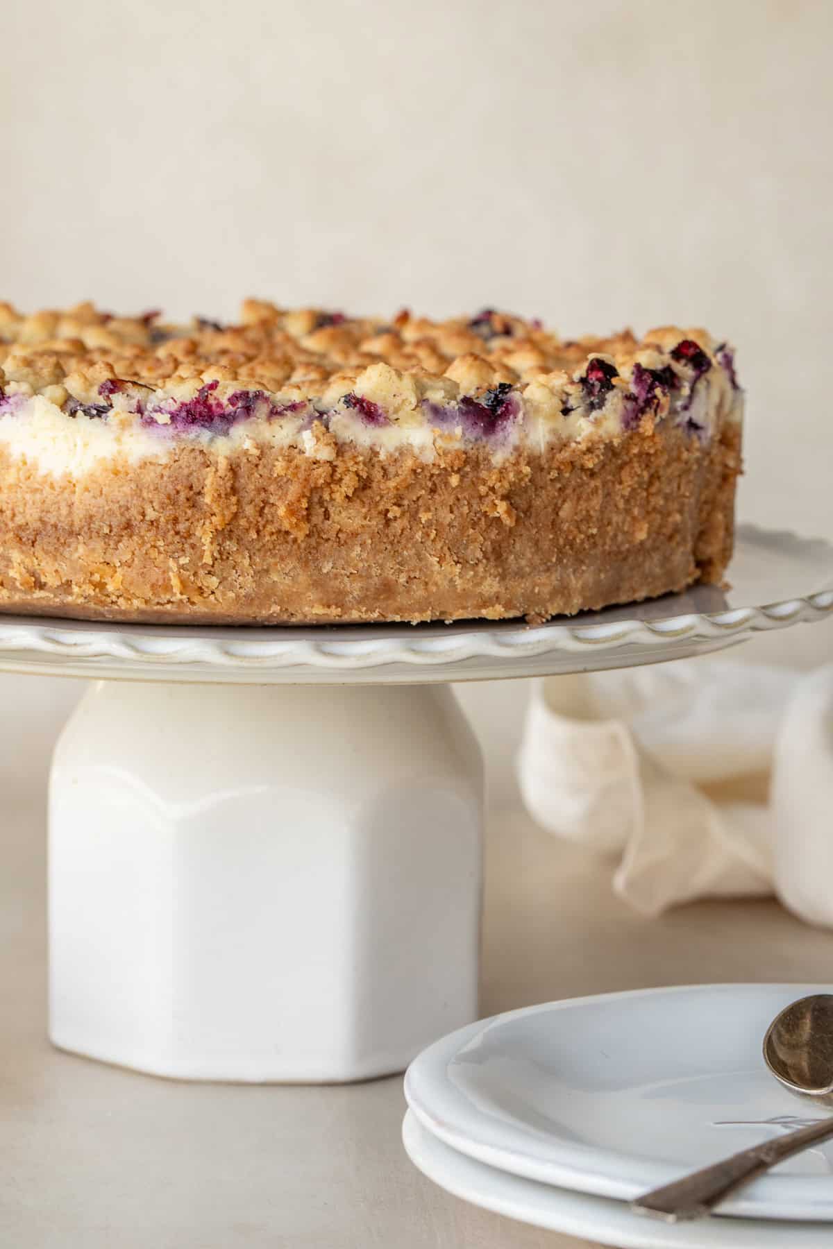 A cake stand with the blueberry cheesecake.
