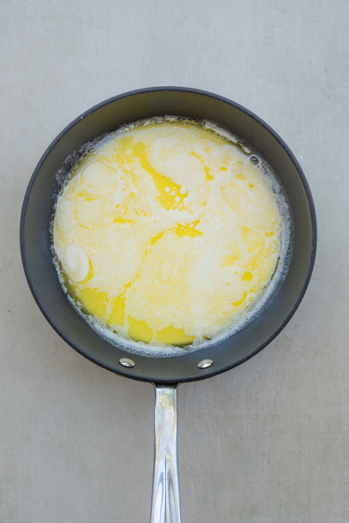 Holiday Cheesy Mashed Potatoes Side Dish A pan with the melted butter and cream.
