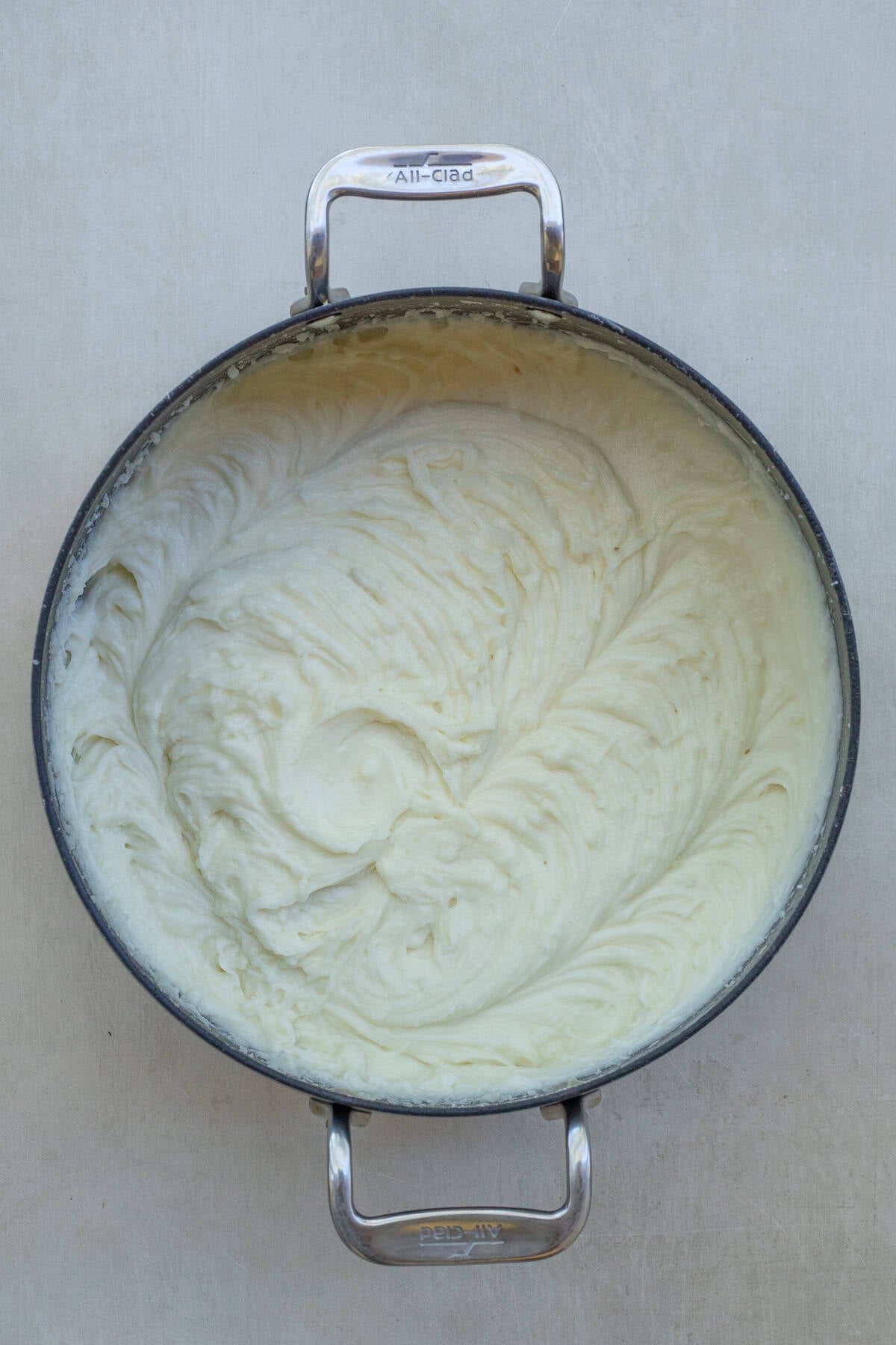 Mashing Potatoes with Butter and Cream A bowl of the mashed potatoes with cream.