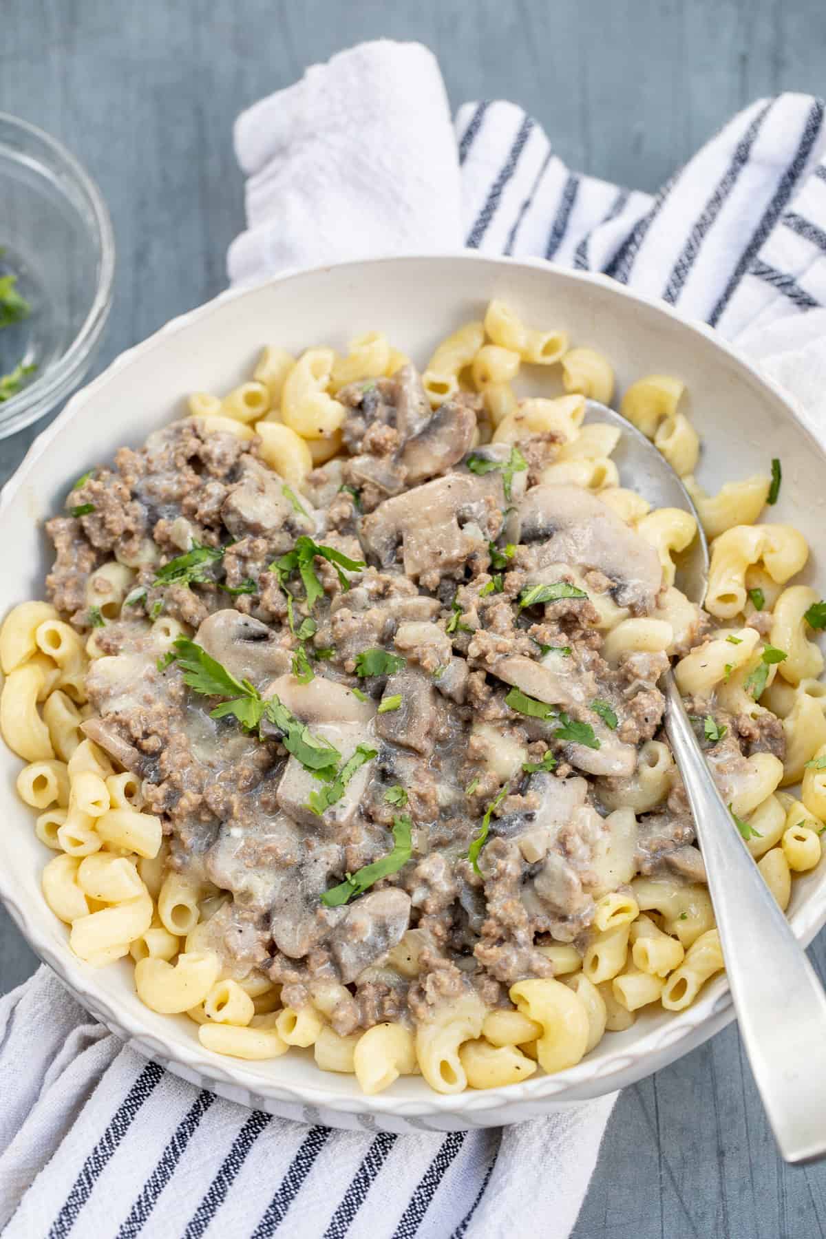 Homemade ground beef stroganoff served over tender egg noodles for an easy dinner. A bowl with egg noodles topped with creamy ground beef stroganoff.