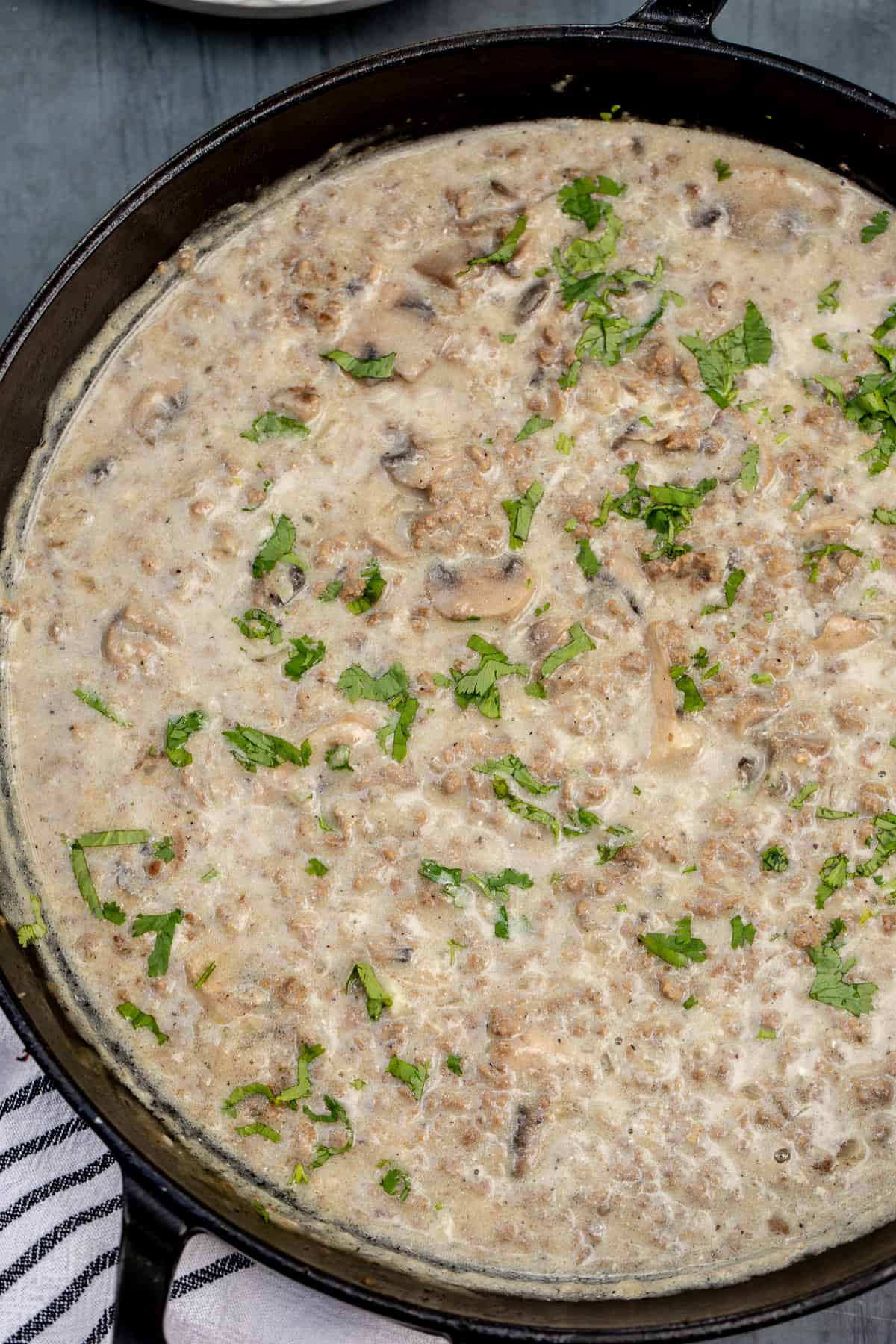 Ground beef stroganoff made with ground beef, mushrooms, and a creamy sour cream sauce. A pan with the creamy beef stroganoff.